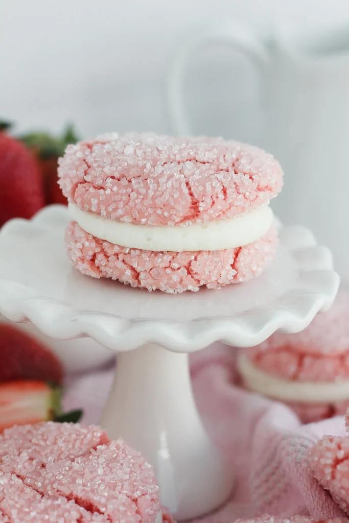 Un macaron à la fraise sur une assiette en suspension blanche