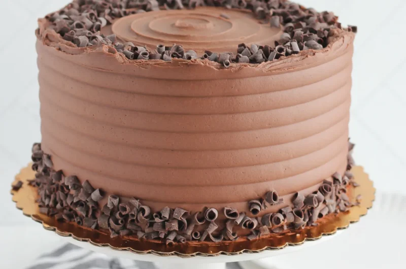 Gâteau aux chocolats sur un plaque doré avec une serviette grise et blanche dans le fond arrière